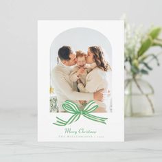 a christmas card with a green bow on it