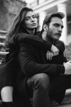 a man and woman sitting on some steps