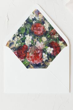 an envelope with a painting of red and white flowers