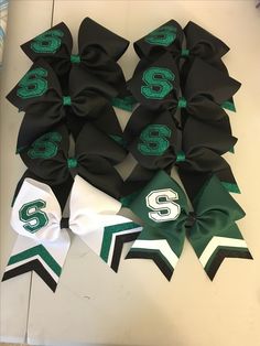 several green and white bows with the number six on them are laying next to each other