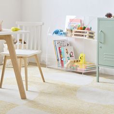 a child's playroom with toys and books on the floor, including a bookcase