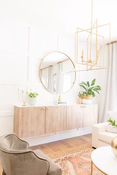 a living room filled with furniture and a large mirror on the wall above it's sideboard