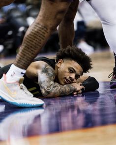 a basketball player laying on the court with his head down