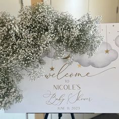 a welcome sign with baby's breath hanging from the front and back of it