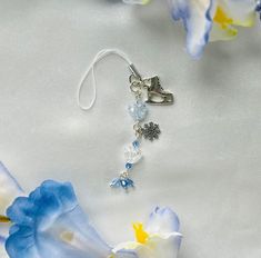 a pair of scissors and some flowers on a white surface with blue, yellow and white petals