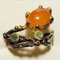 Very Unique Artistic Ring! Natural Carnelian And Emerald In Sterling Silver, Stamped 925. Black Rhodium Plated With 14k Gold Overlay Accents For Contrast And Highlighting The Stones. Please Check Out My Other Jewelry Listings And More Goodies. Thank You ! No Poshmark Account Yet? Use Invite/Referral Code Makeanoffernow And Get 10$ Posh Credit When You Join Poshmark, Good Toward Any Purchase Sitewide. Weird Rings Unique, Orange Bohemian Jewelry With Cabochon, Bohemian Orange Cabochon Jewelry, Orange Multi-stone Round Rings, Orange Multi-stone Ring Jewelry, Orange Multi-stone Ring, Unique Orange Ring Jewelry, Unique Oval Orange Jewelry, Unique Orange Cabochon Ring