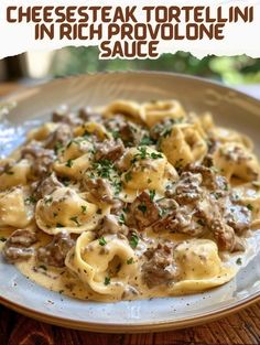 a white plate topped with pasta covered in meat and sauce on top of a wooden table