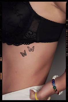 a woman's stomach with two butterflies on her left side, and the bottom part of her belly