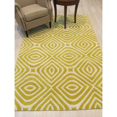 an area rug with yellow and white designs on the floor in front of a chair