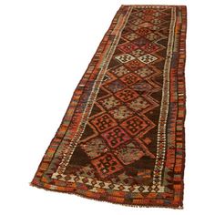 an antique afghan runner rug with red and brown colors on the bottom, two rows of different