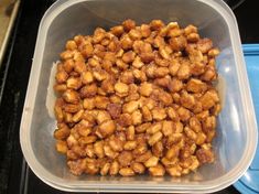 a plastic container filled with food sitting on top of a counter next to a blue bowl