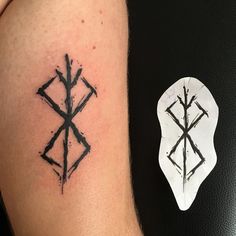 a black and white photo of a tattoo on someone's arm with an arrow in the middle