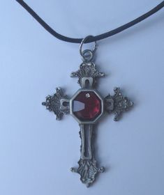 This is a beautiful hand crafted genuine pewter cross necklace. The center of the cross is a genuine red colored faceted Swarovski crystal. The necklace comes on a black cord.The cross is approximately 2 3/4" long and 1 3/4" wide. The cross comes packaged in a gift box. Adjustable Gothic Cross Pendant Jewelry, Red Cross Pendant Necklace Gift, Red Cross Pendant Necklace For Gift, Red Crucifix Cross Necklace Gift, Red Crucifix Cross Necklace For Gift, Gothic Crucifix Cross Necklace For Gift, Gothic Crucifix Cross Necklace As Gift, Gothic Cross Necklace Gift, Red Spiritual Cross Pendant Jewelry