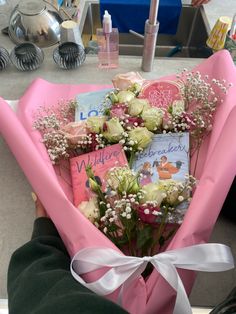 a bouquet of flowers is wrapped in pink paper