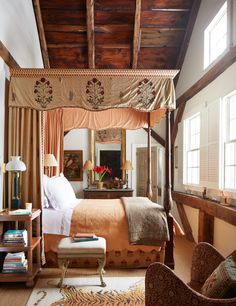 a bedroom with a four poster bed in the center and an ottoman on the other side