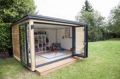 a small wooden shed sitting on top of a lush green field