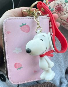 a person holding a keychain with a dog on it