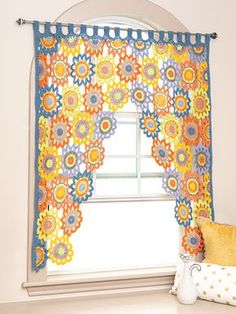 the window is decorated with colorful flowers and polka dot curtains, along with a decorative pillow