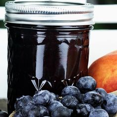 blueberries and peaches sit next to a jar of jam