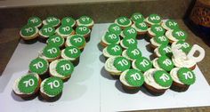 cupcakes with green icing and white frosting are arranged in the shape of numbers