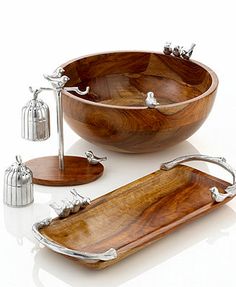 a wooden bowl and two serving trays with silver handles