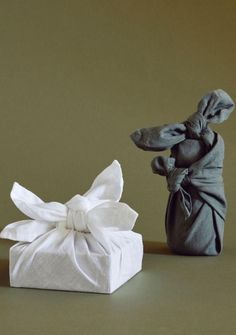 a small white present box next to a ceramic figurine