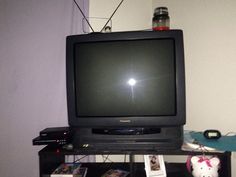 an old television sitting on top of a black shelf