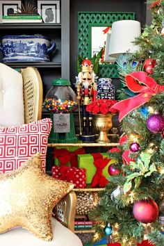 a decorated christmas tree in front of a shelf with ornaments and other holiday decorations on it