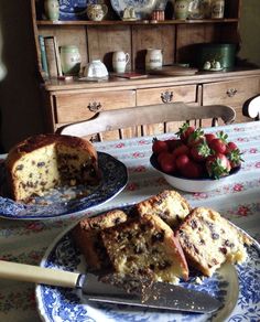 two plates with slices of cake and strawberries on the table