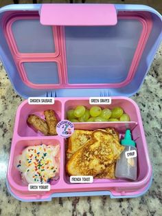 a pink and blue lunch box filled with food