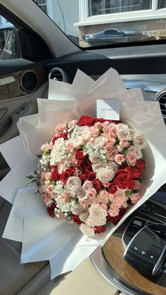 a bouquet of flowers sitting on top of a car dashboard