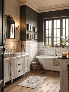 a bathroom with white and gray walls, wooden floors and an old fashioned bathtub