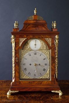 an antique wooden clock sitting on top of a table