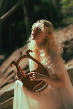 a woman in a white dress holding a harp