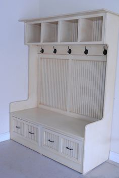 a white bench with two drawers and three bins on the bottom shelf next to it