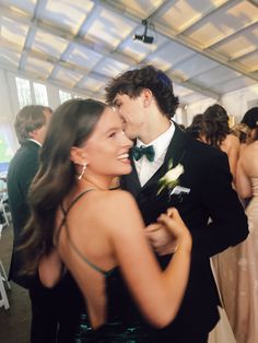 a man in a tuxedo is hugging a woman