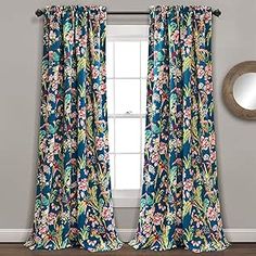 the curtains in this room are blue and green with flowers on them, along with a mirror