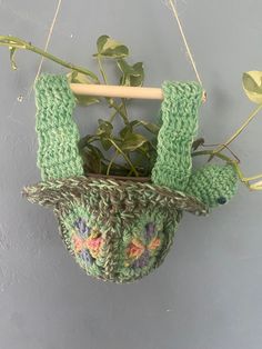 a potted plant hanging from a hook on a wall