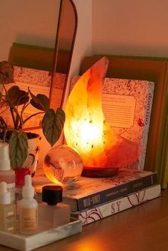 a lamp that is sitting on top of a table next to some books and other items