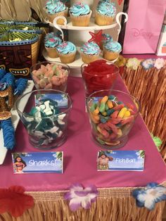 a table topped with lots of cupcakes and candy