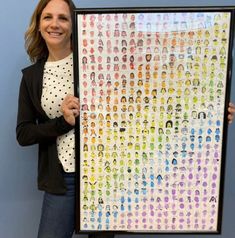 a woman holding up a large poster with many different people on it's sides