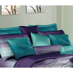 a bed with purple and teal comforters on it