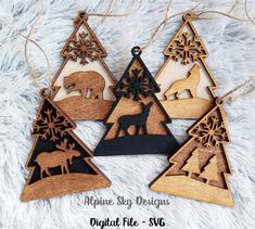 three wooden ornaments with animals and snowflakes hanging on a white fur covered surface