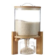 a wooden stand with a glass container on it and a grain dispenser