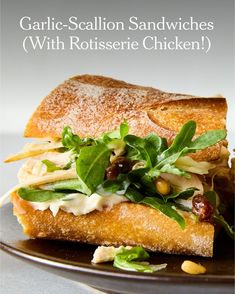 there is a sandwich with lettuce and other vegetables on the plate that says garlic - scallion sandwiches with rotissee chicken