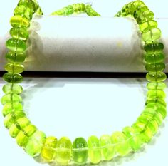 green and yellow glass beads on a white surface