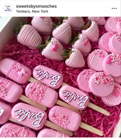 there are many heart shaped lollipops in the box with pink frosting