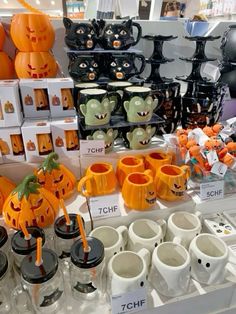 there are many halloween themed items on display at this store, including cups and mugs