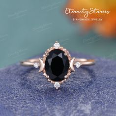 an oval black diamond surrounded by white diamonds on top of a blue velvet surface with the words