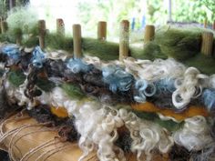 several skeins of yarn are sitting on a piece of wood